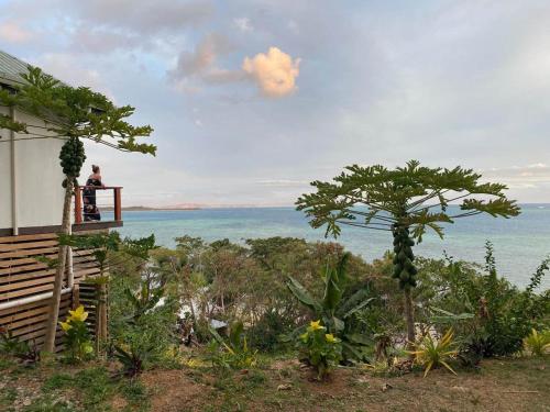 a man sitting on a balcony looking at the ocean at Private Oceanfront Fijian Villa Sleeps 8 in Malolo