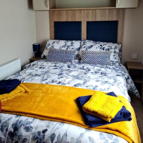 a bed with a yellow blanket on top of it at Georgia Lodge in Knaresborough