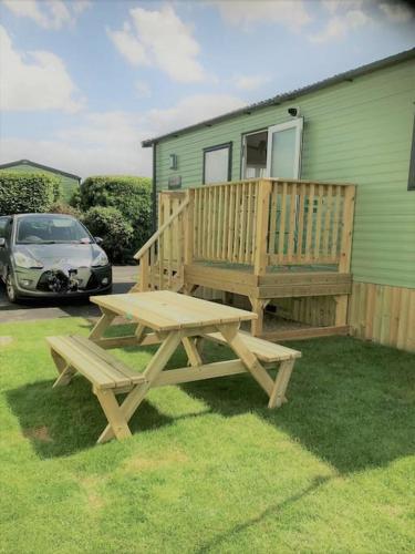 a wooden picnic table in front of a house at Georgia Lodge in Knaresborough