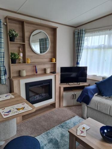 a living room with a couch and a fireplace at Georgia Lodge in Knaresborough