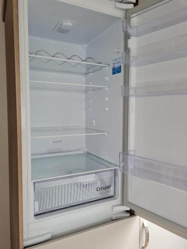 an empty refrigerator with its door open in a kitchen at Georgia Lodge in Knaresborough