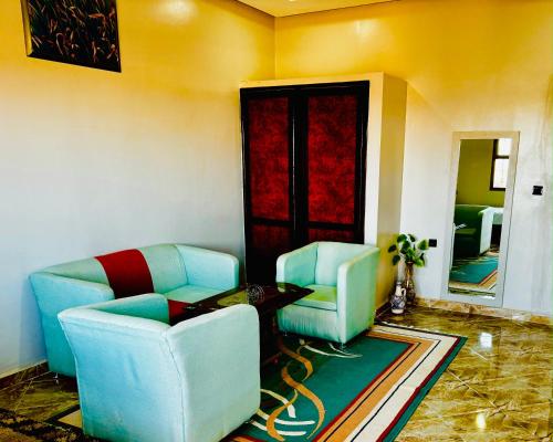a living room with two chairs and a table at COMPLEXE L'OASIS in Erfoud