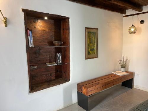 Cette chambre est dotée d'un banc en bois sur un mur. dans l'établissement Casa El granero de Antonio, à San Miguel de Abona