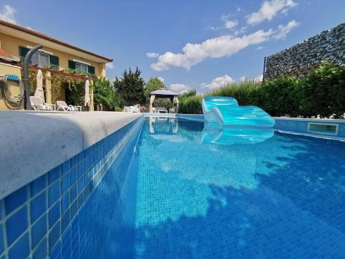 - une piscine bleue avec une chaise en plastique bleu dans l'établissement Vacation house Mater, à Žrnovnica