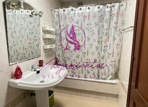 baño con lavabo y cortina de ducha en Ático Doctor Fleming, en Vilagarcía de Arousa