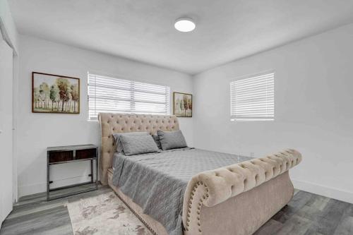 a bedroom with a large bed with a tufted headboard at 4 bedroom 3 bath villa in Fort Lauderdale