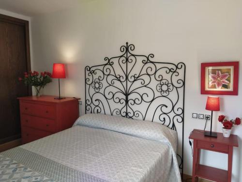 a bedroom with a bed and a dresser with two lamps at Apartamento Gandía, Orihuela del Tremedal. in Orihuela del Tremedal