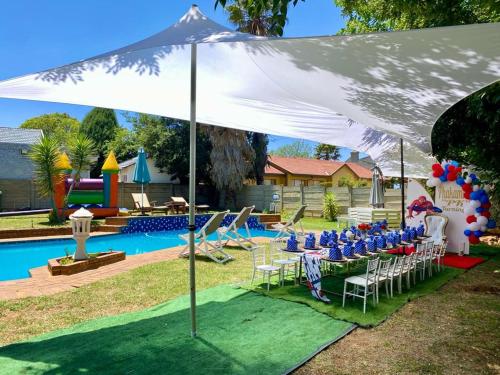 a white tent with chairs and a pool at Horizon Garden Party & Events Venue in Randfontein