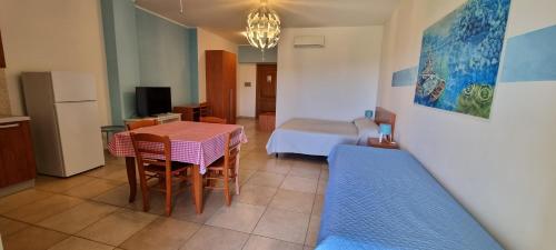 ein Wohnzimmer mit einem Tisch und ein Schlafzimmer in der Unterkunft CATONA HOUSE in Otranto
