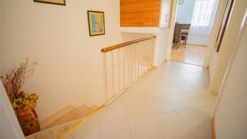 a hallway with a staircase with white tile floors at Apartmani Ana in Tivat