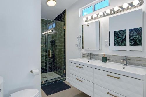 uma casa de banho branca com um lavatório e um chuveiro em Shelby Sands em Palm Springs