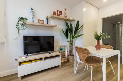 a living room with a television and a table and chairs at Guest H4U - Porto Bonfim Heroismo in Porto