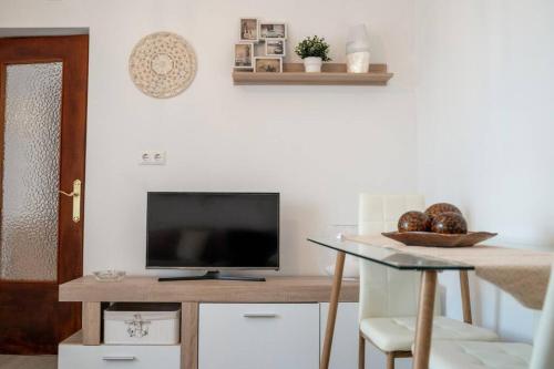 sala de estar con TV y mesa con mesa en Casa Alfocea en Caravaca de la Cruz