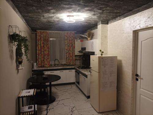 Il comprend une cuisine équipée d'un réfrigérateur et d'une table. dans l'établissement Centrul Vechi Aparthotel, à Brăila