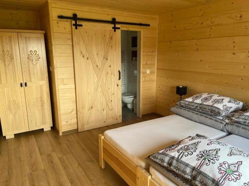 a bedroom with two beds and a bathroom with a toilet at Orawska Knieja 2.0 in Lipnica Wielka