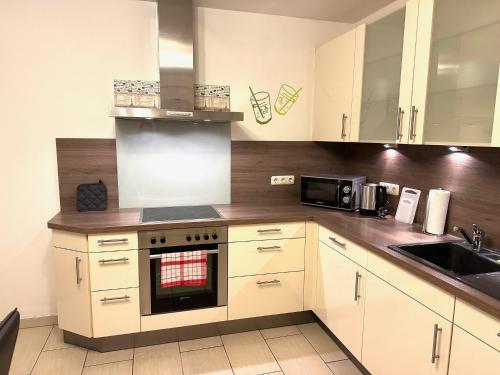 a kitchen with white cabinets and a stove top oven at Ferienwohnung in Oberahr in Oberahr