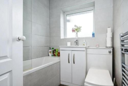 a white bathroom with a tub and a sink at Lovely 2 bedroom flat in Luton no kitchen facilities free parking in Luton