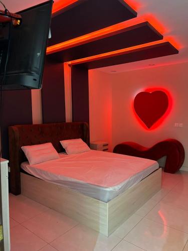 1 dormitorio con 1 cama con un corazón en la pared en استراحة زهرة الاماكن (1) en Yeda