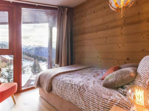 a bedroom with a bed and a large window at Appartement Les Arcs 1800, 4 pièces, 8 personnes - FR-1-346-321 in Arc 1800