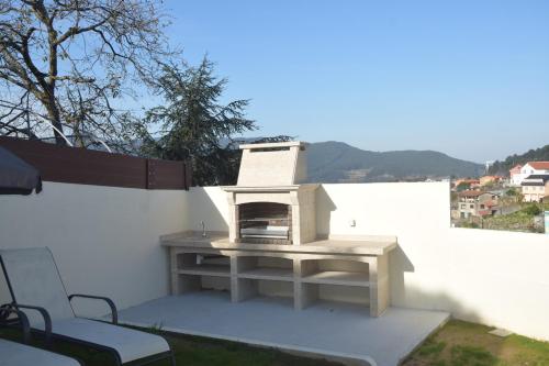 einem Pizzaofen auf einer Terrasse in der Unterkunft Casa en Chapela, al lado de Vigo y con vistas a la Ría in Redondela