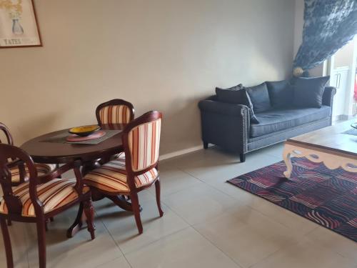 a living room with a table and chairs and a couch at Modern Seaview Apartment in Summerstrand