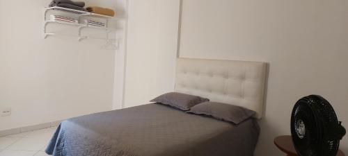 a white bedroom with a bed with two pillows at Apartamento completo e bem localizado in Vitória da Conquista