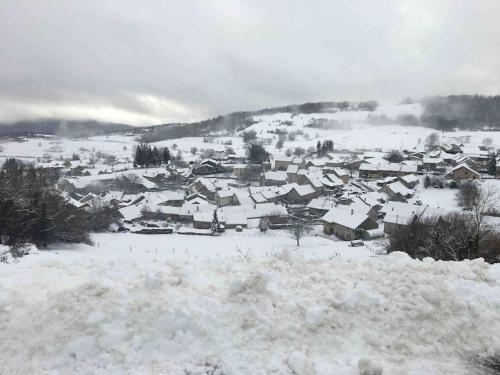 a small town covered in snow on a mountain at Au Moryllon in Lompnas