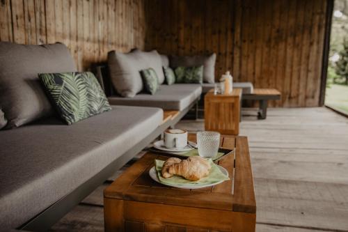 a living room with couches and a plate of food on a table at Feldgärtenhof in Silandro