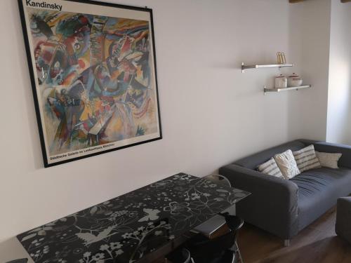 een woonkamer met een bank en een schilderij aan de muur bij Appartamento in centro Bergamo in Bergamo