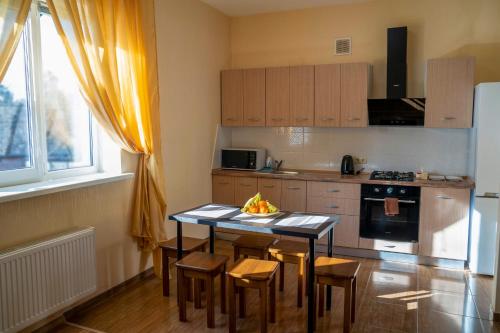 a kitchen with a table and chairs and a kitchen with a stove at Guest house Kiev forest in Kyiv