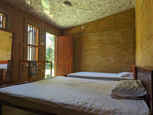 a bedroom with two beds and a ceiling at P&G Hotel and Water Purification Center in Hambantota