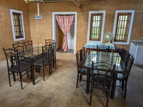 uma sala de jantar com uma mesa de vidro e cadeiras em P&G Hotel and Water Purification Center em Hambantota