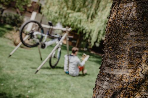 a boy sitting in the grass next to a bike at Feldgärtenhof in Silandro