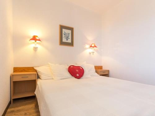 a bedroom with a white bed with a red heart pillow at Appartement La Rosière, 2 pièces, 6 personnes - FR-1-275-150 in La Rosière