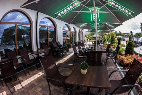 an outdoor patio with tables and chairs and umbrellas at Złote Arkady in Częstochowa