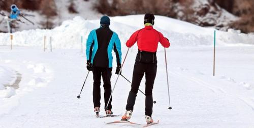 two people walking through the snow on skis at Hotellet i Jörn AB in Jörn