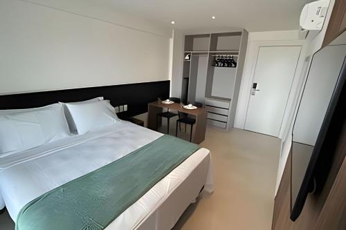 a bedroom with a large bed and a table at Studios Premium RN in Maceió