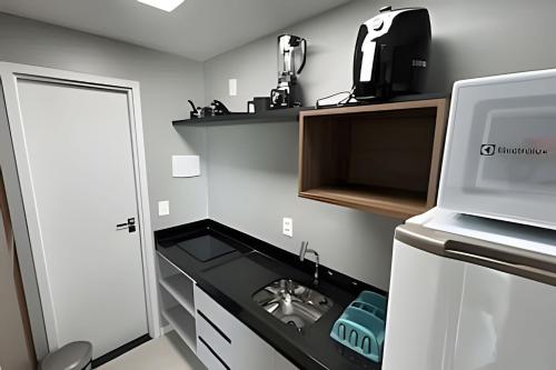 a small kitchen with a sink and a microwave at Studios Premium RN in Maceió