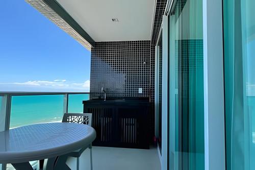 a balcony with a table and a view of the ocean at Studios Premium RN in Maceió