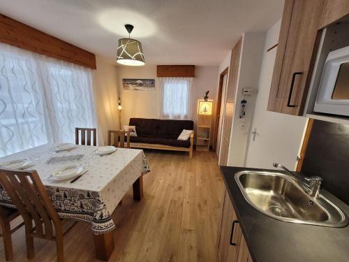 une cuisine et un salon avec une table et un évier dans l'établissement Appartement 4 pers rénové, lumineux, au centre des Gets, proche pistes et commerces - FR-1-598-114, aux Gets