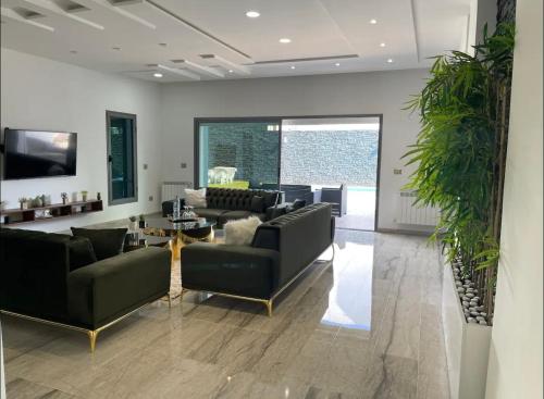 a living room with couches and a table at Villa avec piscine et Jacuzzi Tunis in Mornag