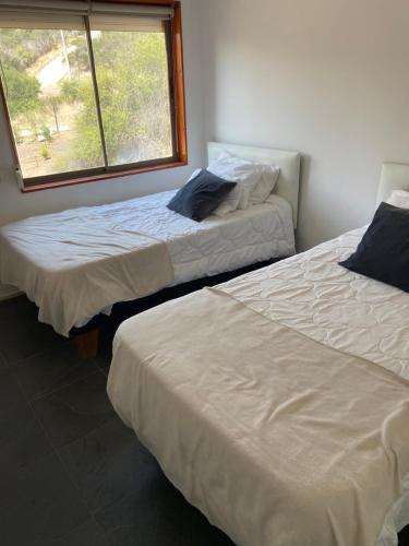 Un pat sau paturi într-o cameră la Casa en parcela Curacavi