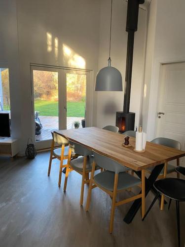 a dining room table and chairs in a room at Moderne sommerhus i naturskønne omgivelser in Gedser