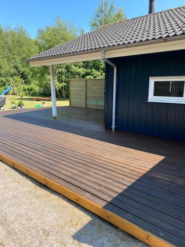 a wooden deck on the side of a house at Moderne sommerhus i naturskønne omgivelser in Gedser