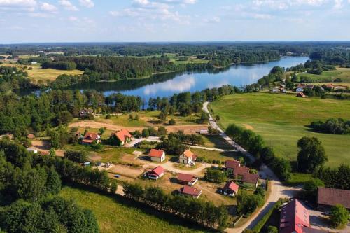 an aerial view of a village next to a river at Domki na Mazurach Kurka Wodna in Mikołajki