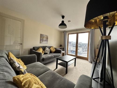 a living room with a couch and a table at Waterside View Apartment in Inverness