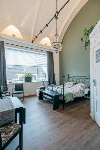 a bedroom with two beds and a table and chairs at Klooster Achthuizen in Achthuizen