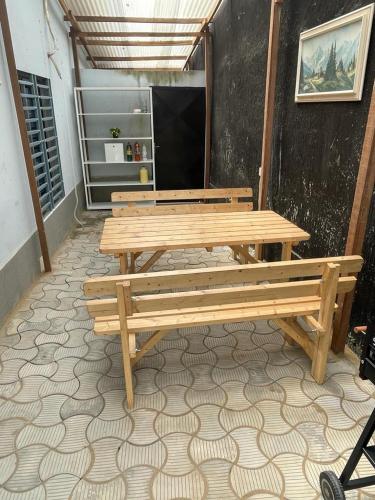 two wooden benches sitting on a floor in a room at Mado Coliving - Studio Appart, Chambre coin cuisine, Chambre in Douala