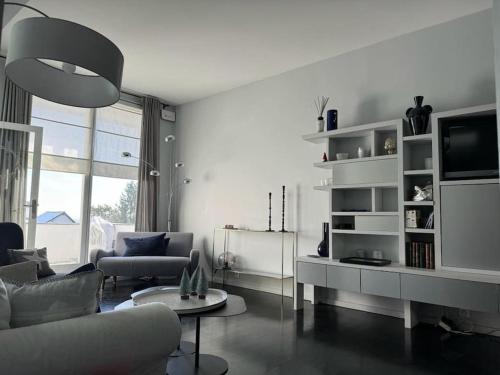 un salon avec un canapé et une télévision dans l'établissement Maison Exceptionnelle ! Vue tour Eiffel et Paris, à Suresnes