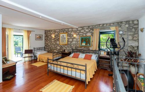 a bedroom with two beds and a stone wall at Rural house Janjić in Ploče